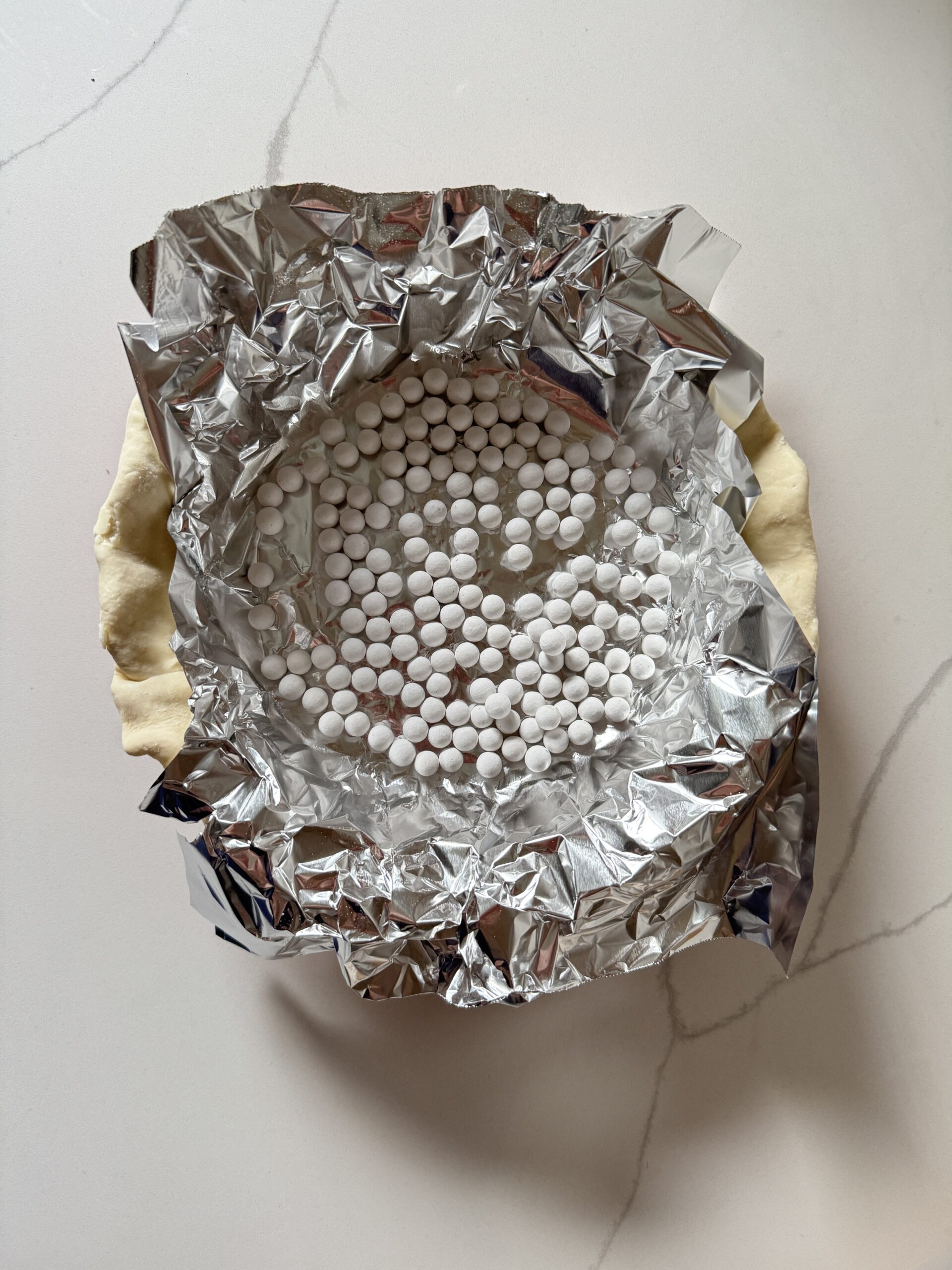 pie crust with foil and pie beads