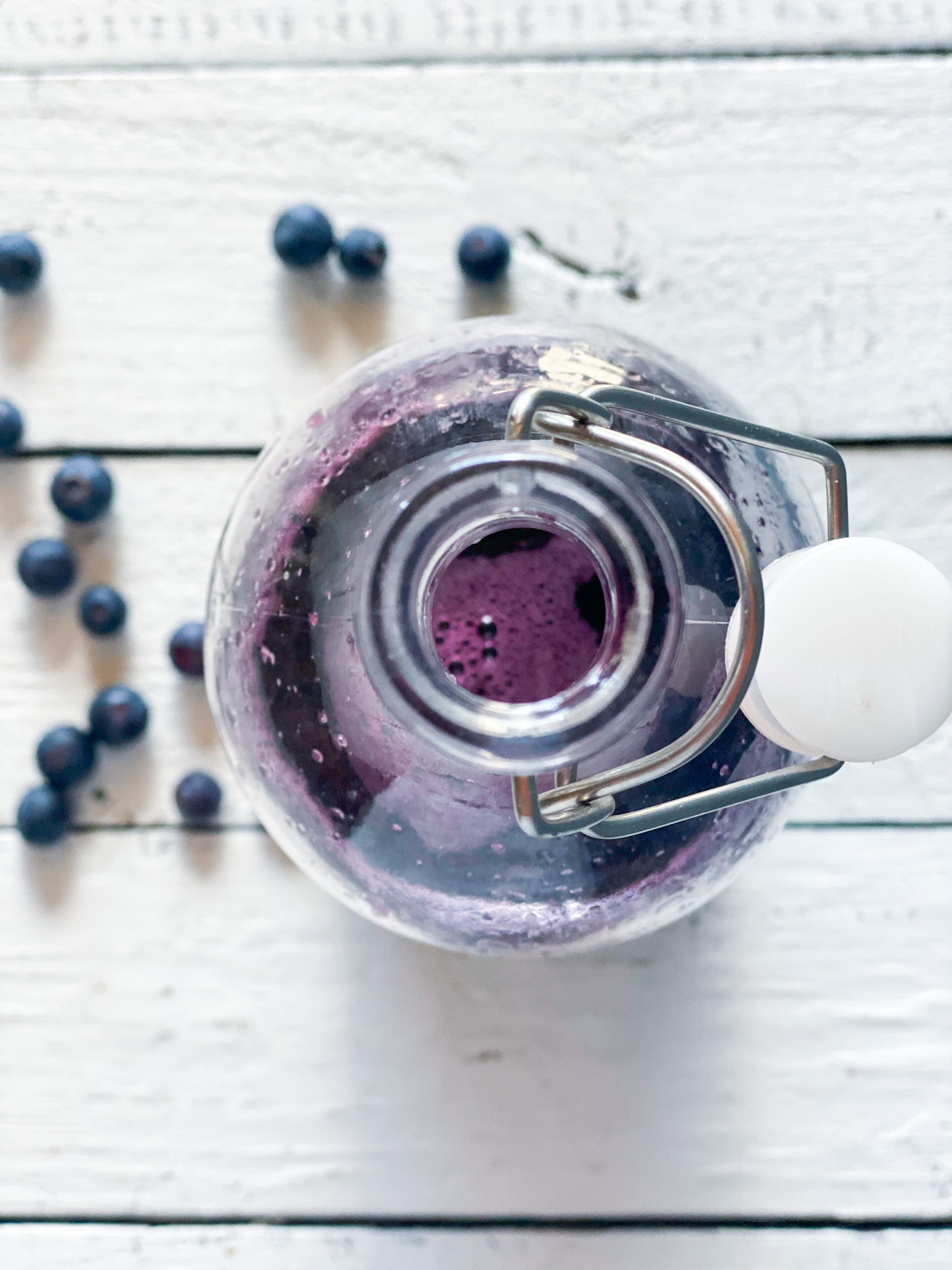 blueberry simple syrup from the top dwn with blueberries on the table