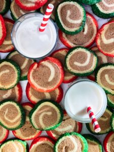 Red and green and chocolate cookies and milk with red and white straws