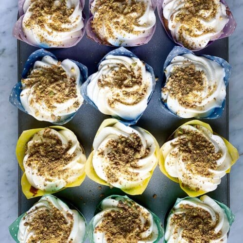 1 dozen pistachio cupcakes with cream cheese frosting and pistachios on top