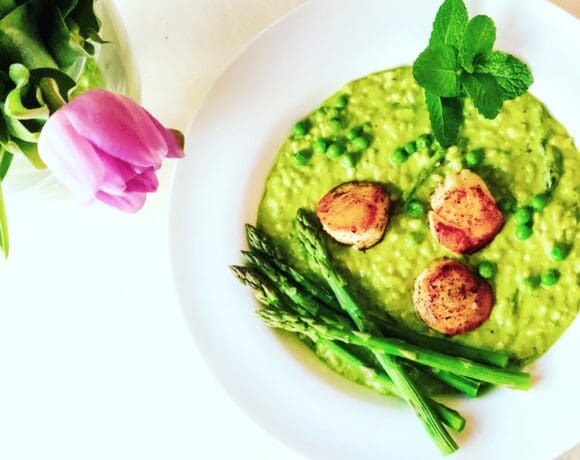 pea risotto on a plate with scallops and asparagus