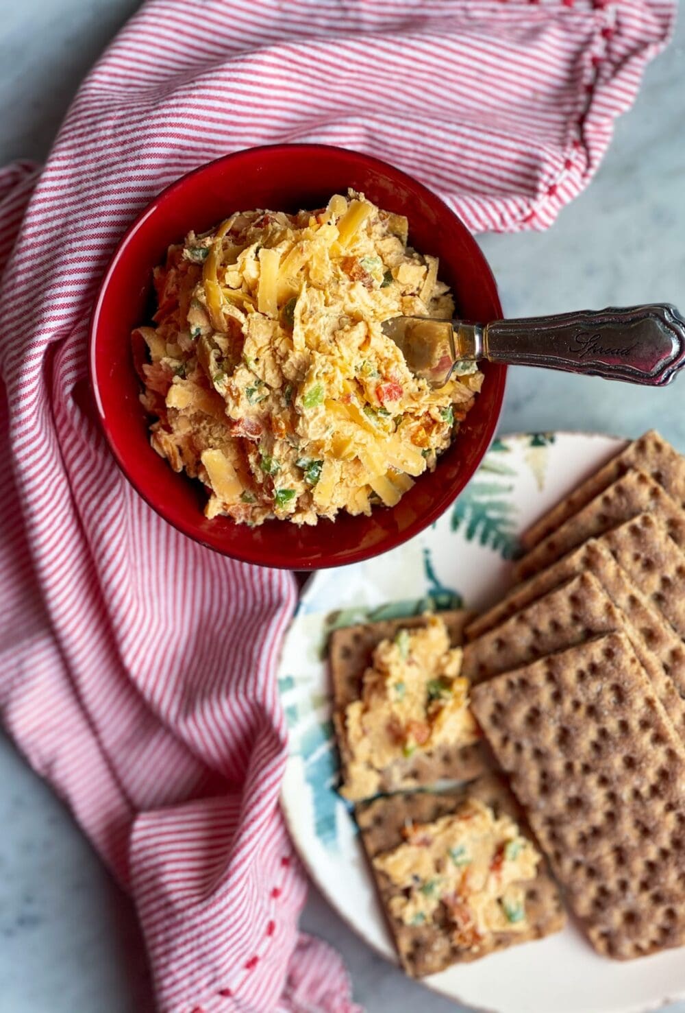 spicy pimento cheese in a bowl with crackers and a napkin
