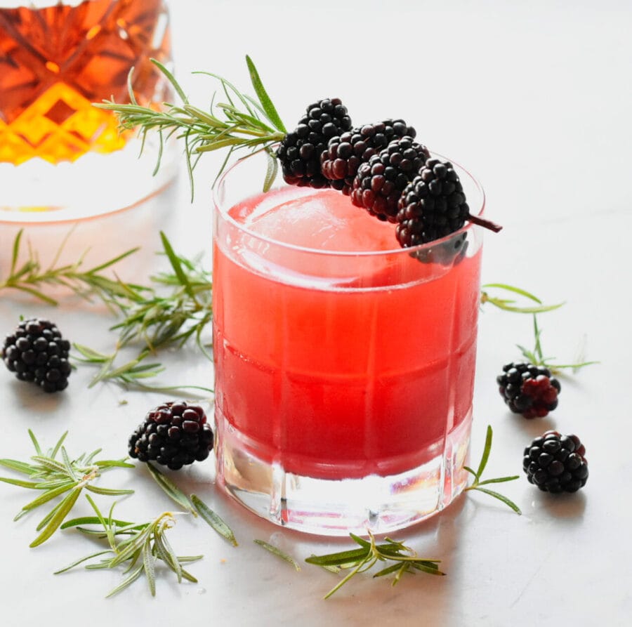 Blackberry and rosemary garnished Bourbon sour with bourbon