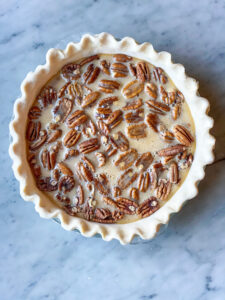 pie crust with pecans and custard, but not baked yet