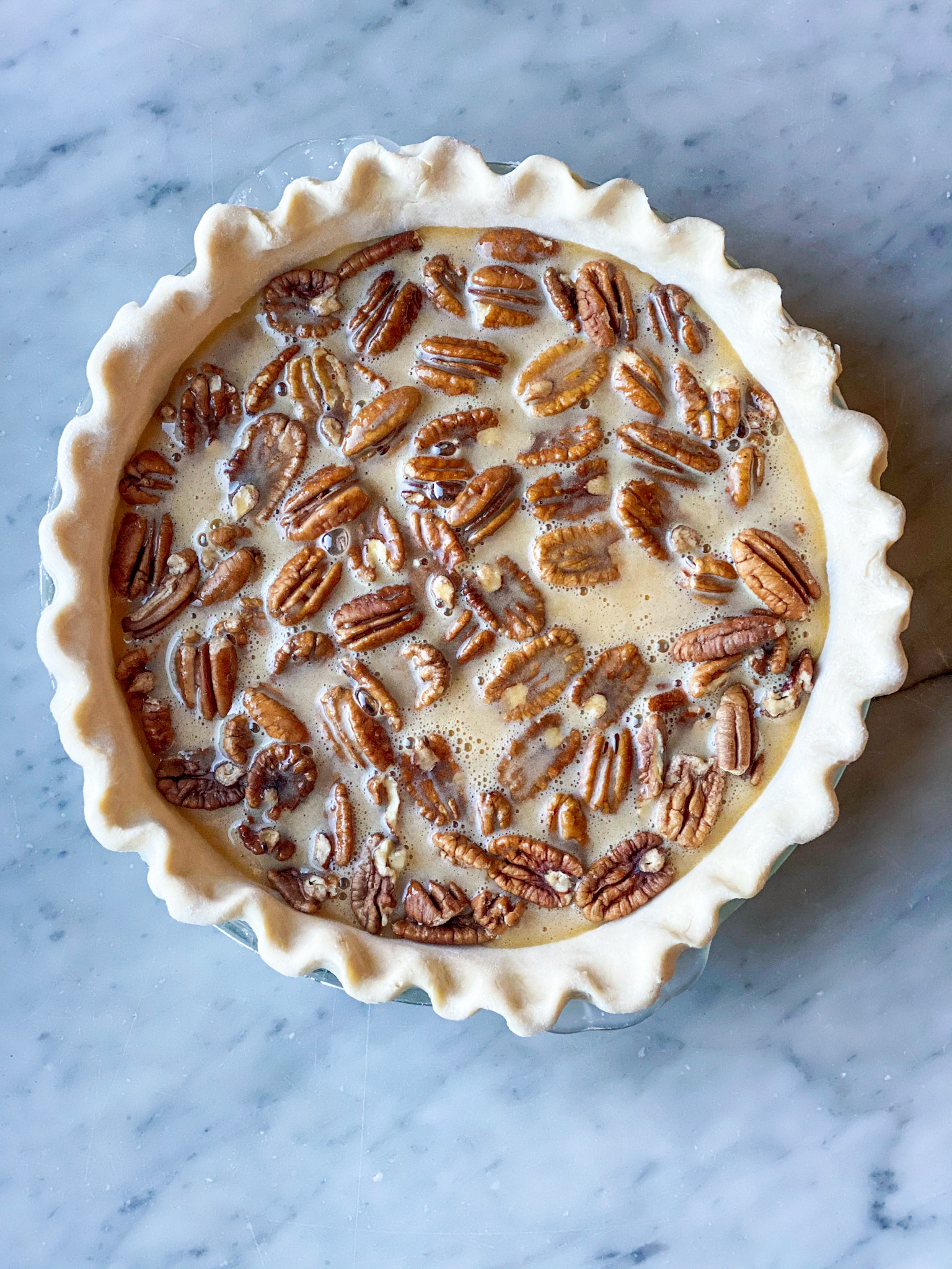 pie crust with pecans and custard, but not baked yet