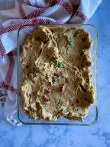 Christmas M&M chocolate chip cookie dough in a glass container, chilled