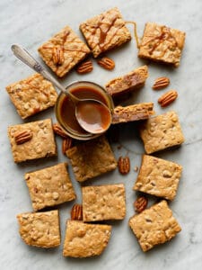 Bourbon blondies cut and on marble with a jar of salted caramel