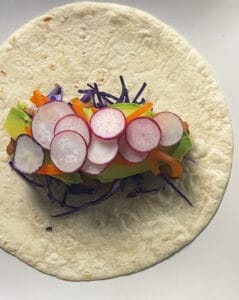 Radish topped fish burrito not yet rolled up