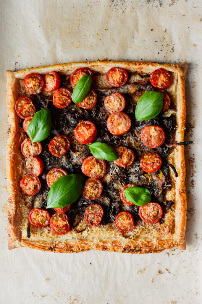 basil and tomatoes on a carmalized onion and tomato tart