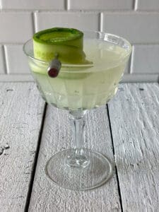 Cucumber martini in a martini glass with a curled cucumber slice for garish