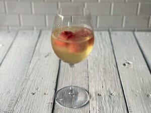 Watermelon ice cubes in a glass of white wine