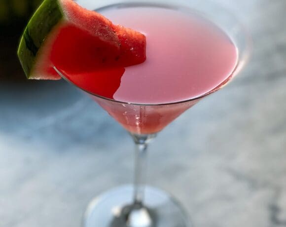 watermelon martini with a watermelon wedge and a watermelon in background