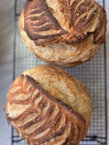 2 loaves of sourdough bread on a cooling rack.