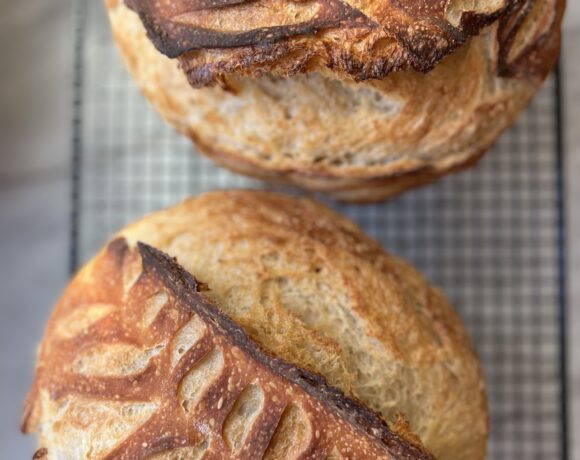 2 loaves of sourdough bread on a cooling rack.