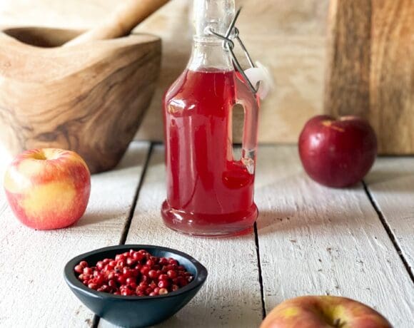 pink peppercorn syrup and apples and a mortar and pistol and pink peppercorn syrup
