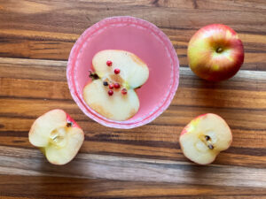 top view of a pink apple martini with apple and apple cut in half