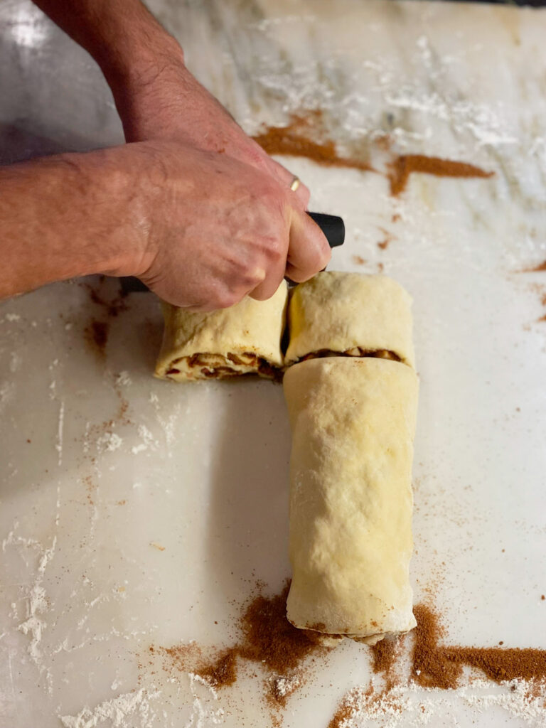 hands cutting apple cinnamon rolls