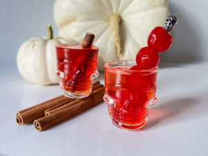 fireball shots in skull glasses with cinnamon sticks and cherries