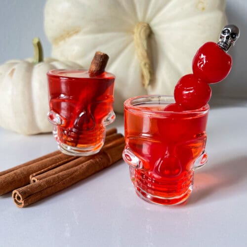 fireball shots in skull glasses with cinnamon sticks and cherries