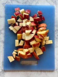 chopped red apple on a blue cutting board