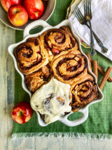 Apple cinnamon rolls with cinnamon sticks and apples