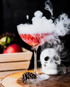 Red poisoned apple cocktail with fog and a skeleton head