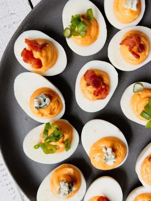 Spicy Deviled Eggs with bleu cheese, green onions and bacon on top