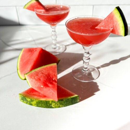 2 watermelon martinis and slices of watermelon