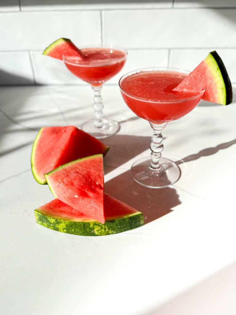 2 watermelon martinis and slices of watermelon