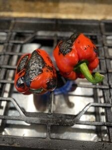 roasting red peppers over a gas flame