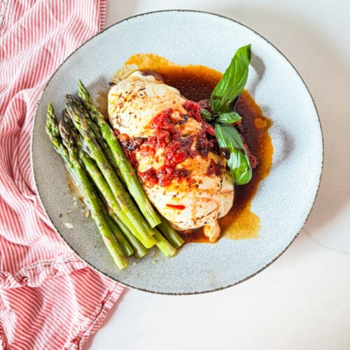 Caprese chicken on a plate with asparagus