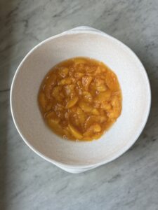 mashed up peaches cooked in a white bowl