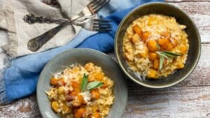 butternut squash risotto in two bowls with a blue napkin