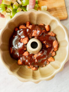 caramel layered over biscuits to make apple monkey bread in a bundt pan