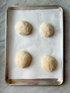 German Pretzel Buns on parchment before boil