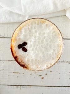 Hazelnut Espresso Martini with coffee beans on top and on the side