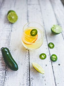 skinny spicy margarita with dried citrus wedge and jalapeño on top
