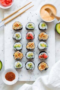 Avocado maki rolls on a white marble with chop sticks