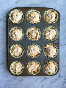 bacon cheese muffin batter in a muffin tin waiting to be baked