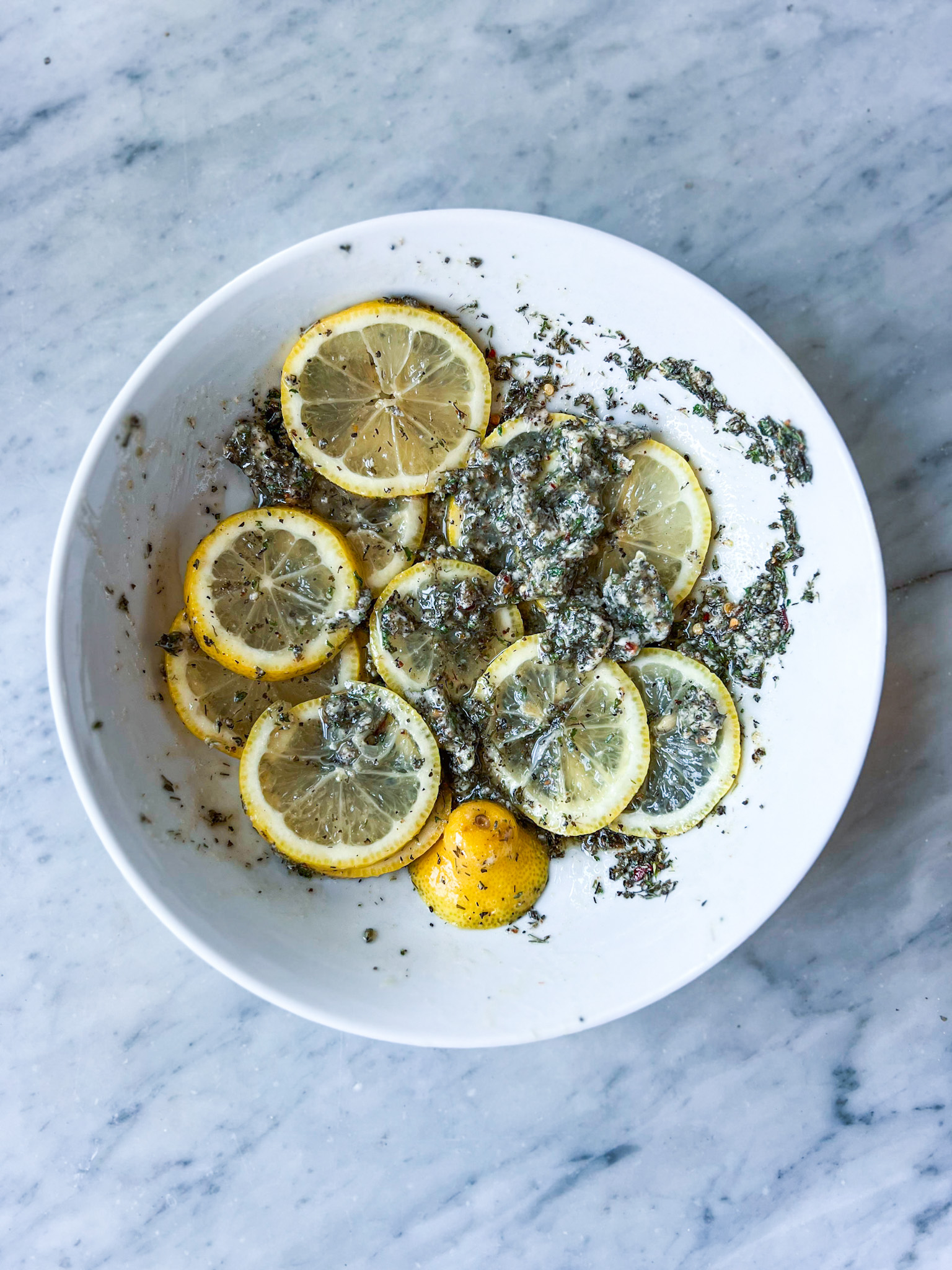 Greek seasoning and butter on lemons in a bowl