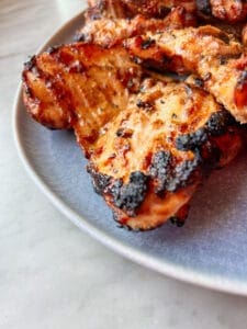 smoked grilled chicken thighs on a blue platter