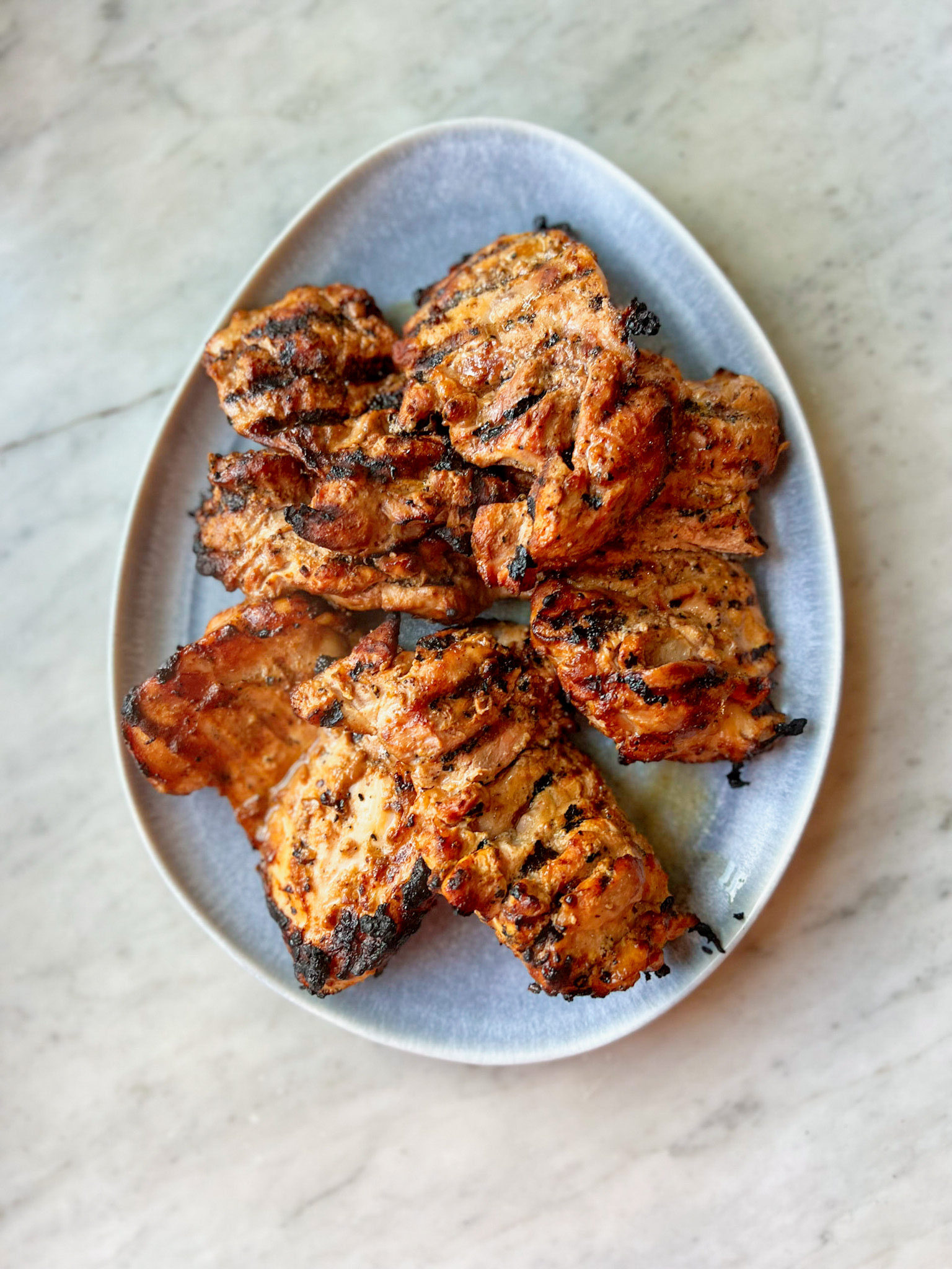 Blue platter of smoked chicken thighs