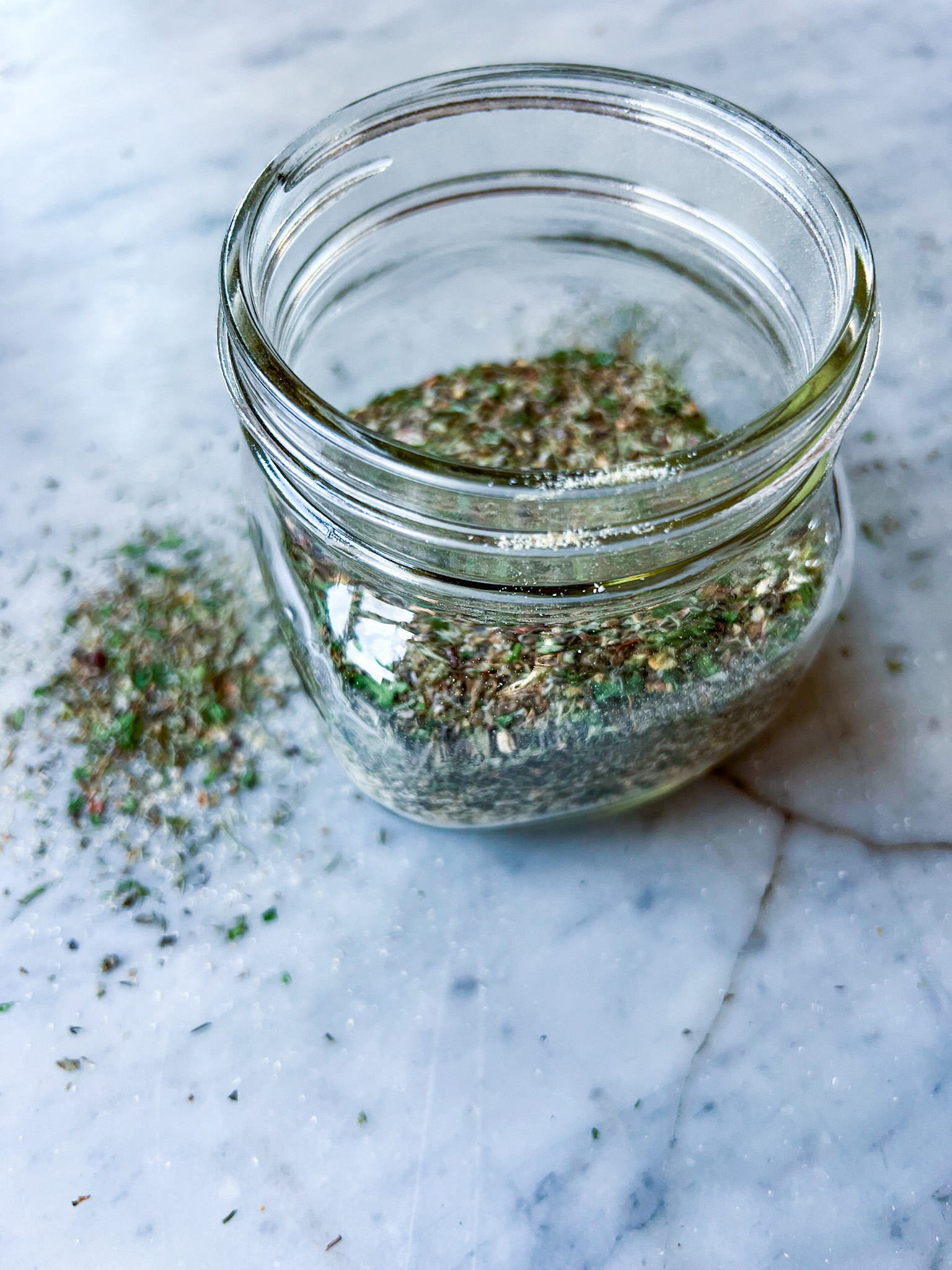 Greek spices in a jar with some on the counter