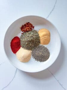 6 spices in a white bowl for pizza seasoning