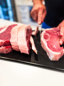 Man cutting steaks from a prime rib.