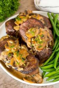 steak diane on plate with green beans