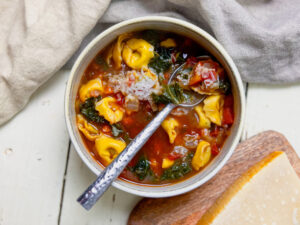 kale and tortelini soup with a spoon horizontal