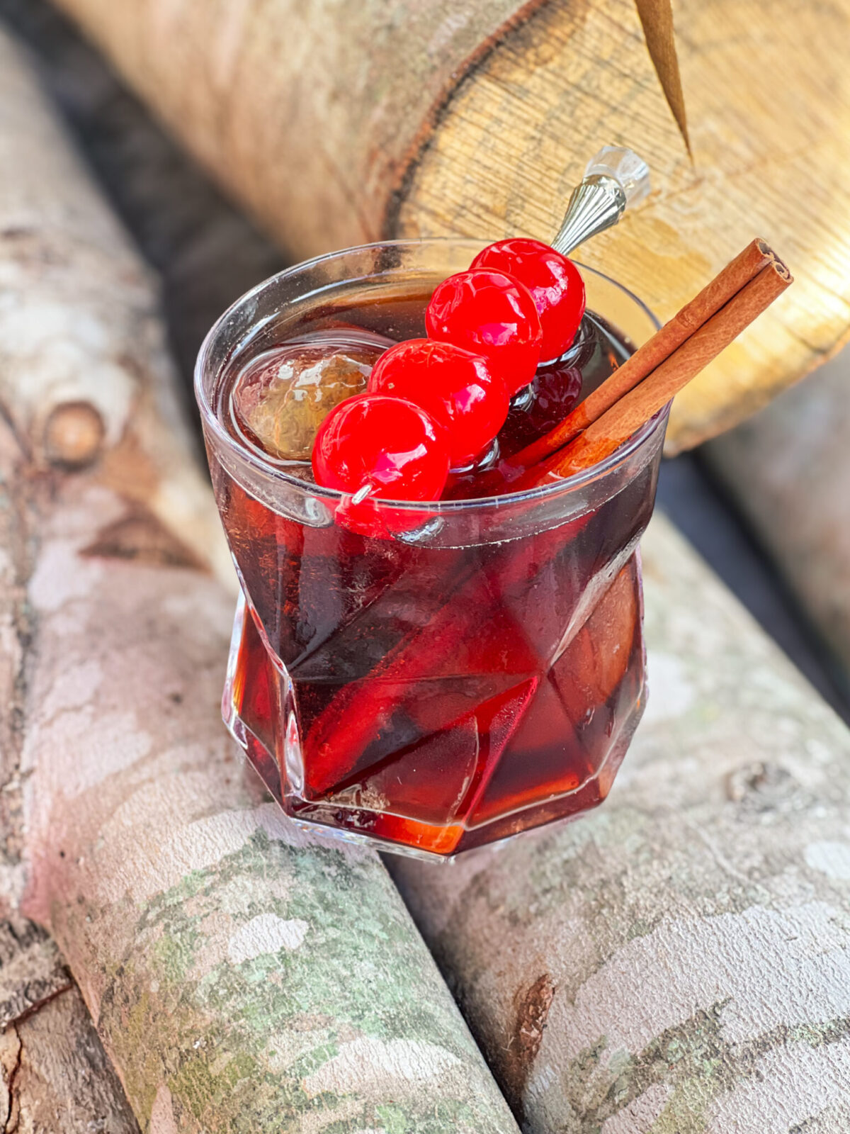 fireball and dr. pepper over ice with cherries and a cinnamon stick