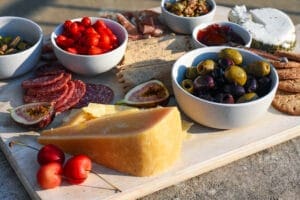 charcuterie board with meats, cheeses, olives, nuts and crackers