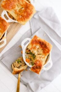 Chicken pot pie in a white pan with handles on a grey napkin